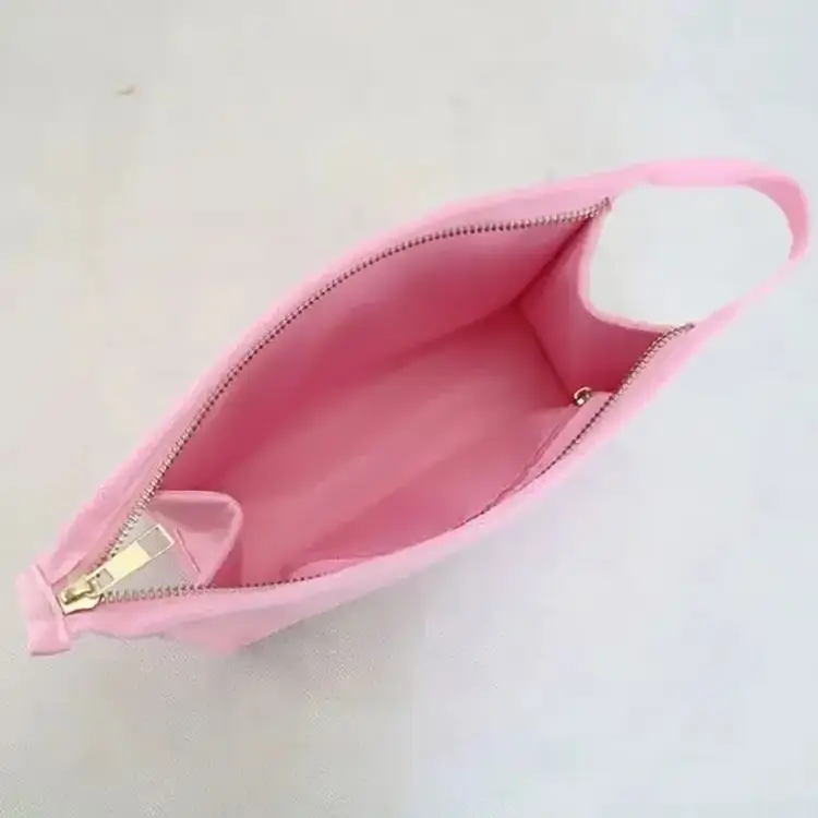 Close-up of rose gold zipper and reinforced stitching on a luxury pink makeup bag, showcasing retail-ready manufacturing quality